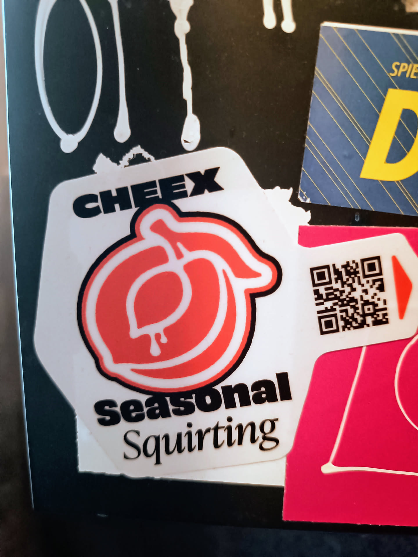 White sticker with a red peach design and the text "CHEEX Seasonal Squirt".  It also includes a QR code.