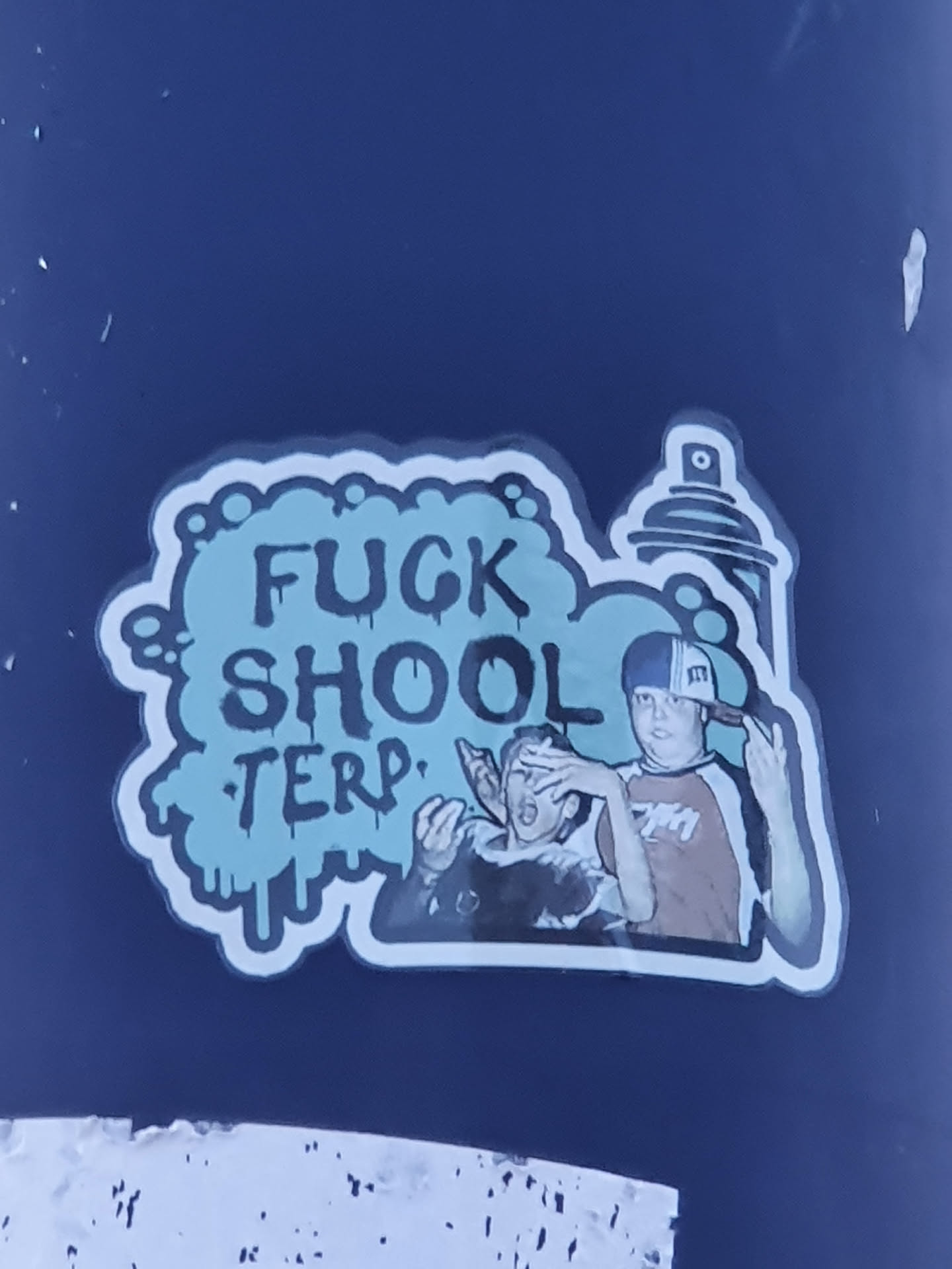 A sticker featuring two boys, one covering the other's eyes, with the phrase "FUCK SHOOL TERP" in graffiti style. The sticker also includes an image of a spray can.