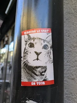 Black and white sticker featuring a close-up of a cat's face. The text 'NARCISS LE CHAT' is at the top, and 'ON TOUR' is at the bottom, both in white on a red background.