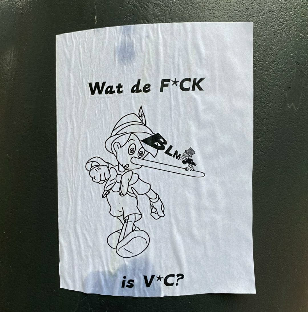 A sticker featuring a drawing of Pinocchio with an extremely long nose. On the nose, it says BLM. The text on the sticker says "Wat de F*CK is V*C?"