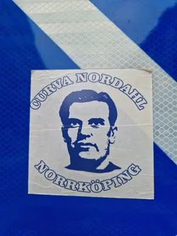 A blue and white sticker featuring a portrait of Nordahl and text that says Curva Nordahl Norrköping.