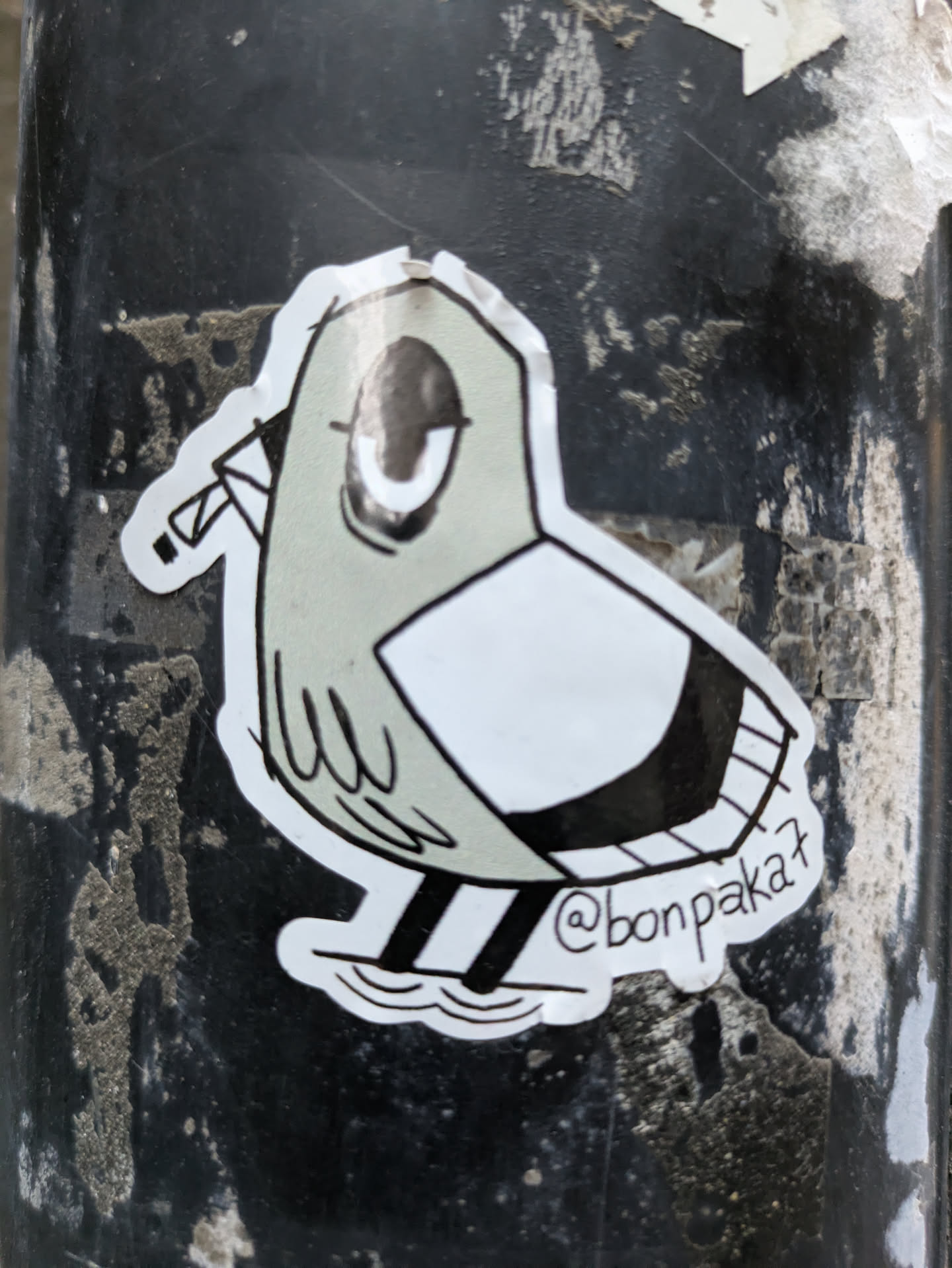 A sticker featuring a stylized bird design. The bird is depicted in grayscale with a simple yet expressive style.  The artist's Instagram handle is visible on the sticker.