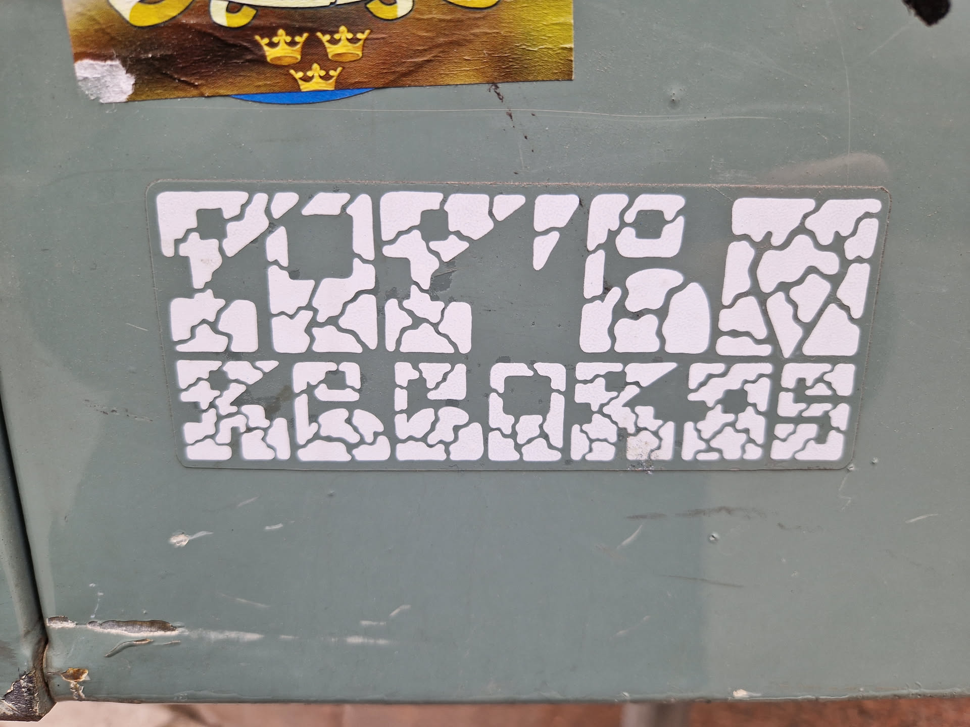 White sticker with the text Top10 Records in a unique cracked pattern design. The sticker is affixed to a light gray surface.
