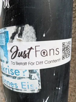 A JustFans promotional sticker with a QR code. The text on the sticker says "JustFans" and "Ta Betalt För Ditt Content!" which translates to "Get Paid For Your Content!" in Swedish.
