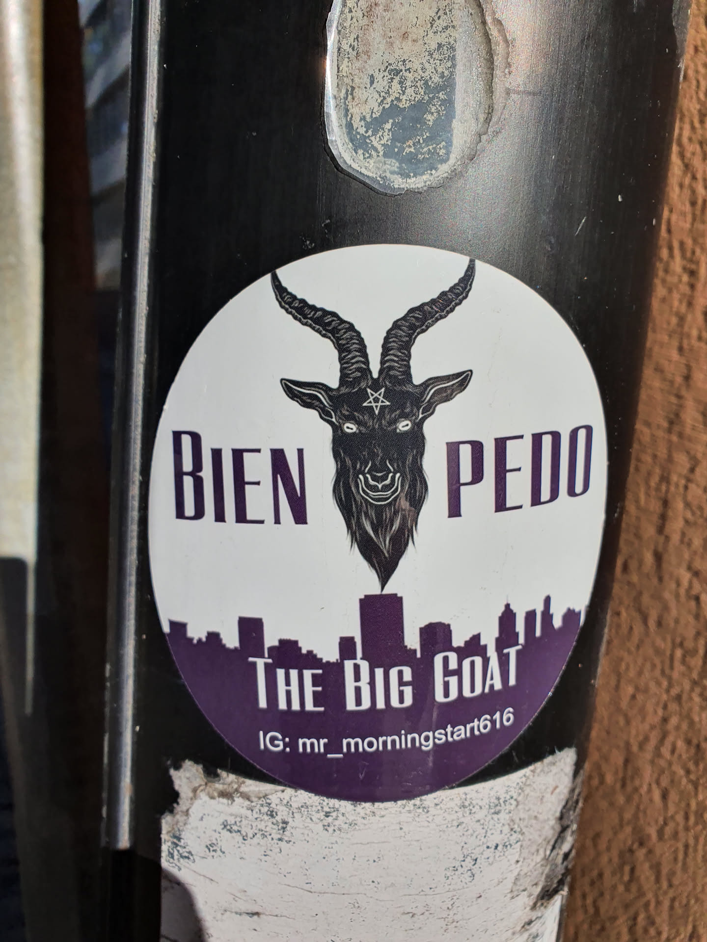 Round sticker with a black goat with horns, a pentagram on its forehead, and a city skyline. The text "Bien Pedo" is written on the top and "The Big Goat" at the bottom. An Instagram handle is also visible at the bottom.