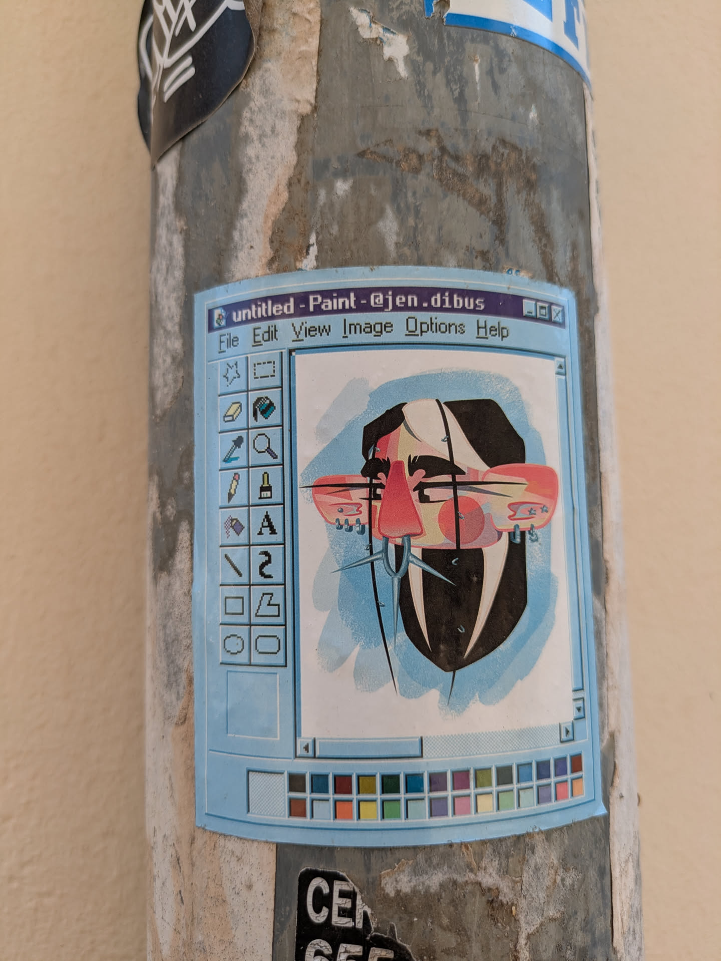 A light blue sticker featuring an abstract face is adhered to a pole. The image is designed to resemble the classic Windows Paint application interface. The 'untitled - Paint - @jen.dibus' title bar is visible at the top. The abstract face is stylized with angular shapes and lines.