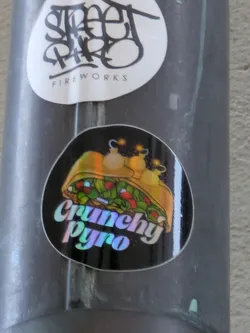 A sticker featuring an illustration of a gyro with fireworks inside. The text "Crunchy Pyro" is written in a holographic font.