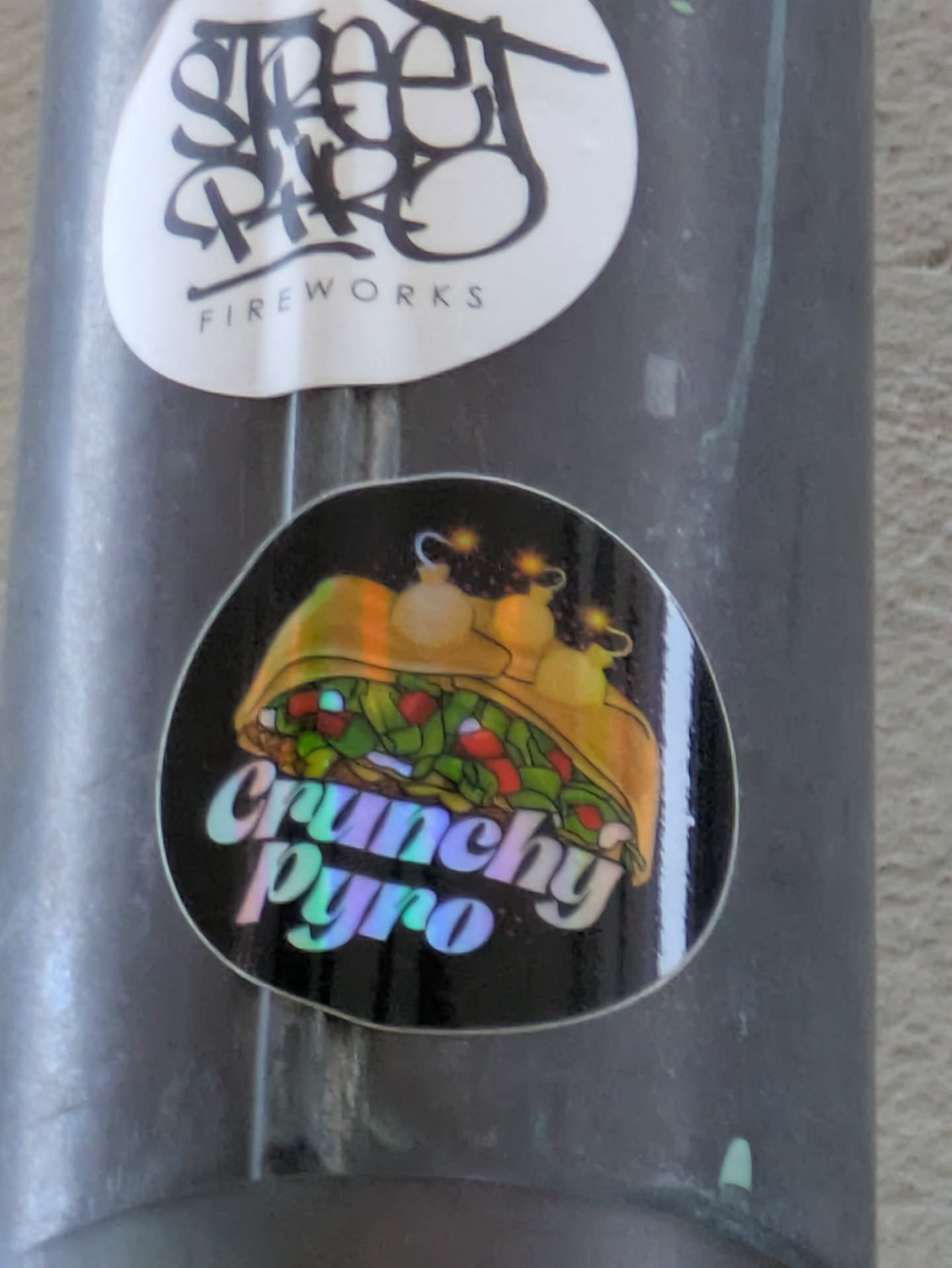 A sticker featuring an illustration of a gyro with fireworks inside. The text "Crunchy Pyro" is written in a holographic font.
