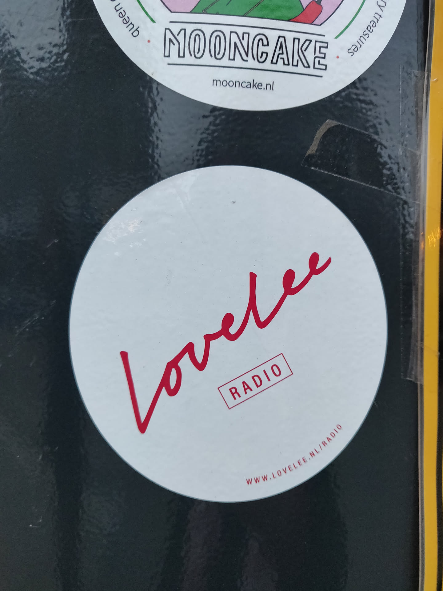 A round white sticker with the word Lovelee written in a red cursive script. Below it, the word RADIO is written in a red box. At the bottom, the website address www.lovelee.nl/radio is printed.