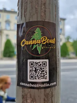 A sticker for CannaBeat Radio. The sticker has a dark background with a logo of a cannabis leaf and the text 'CannaBeat Radio'. It also contains a QR code that leads to cannabeatradio.com.