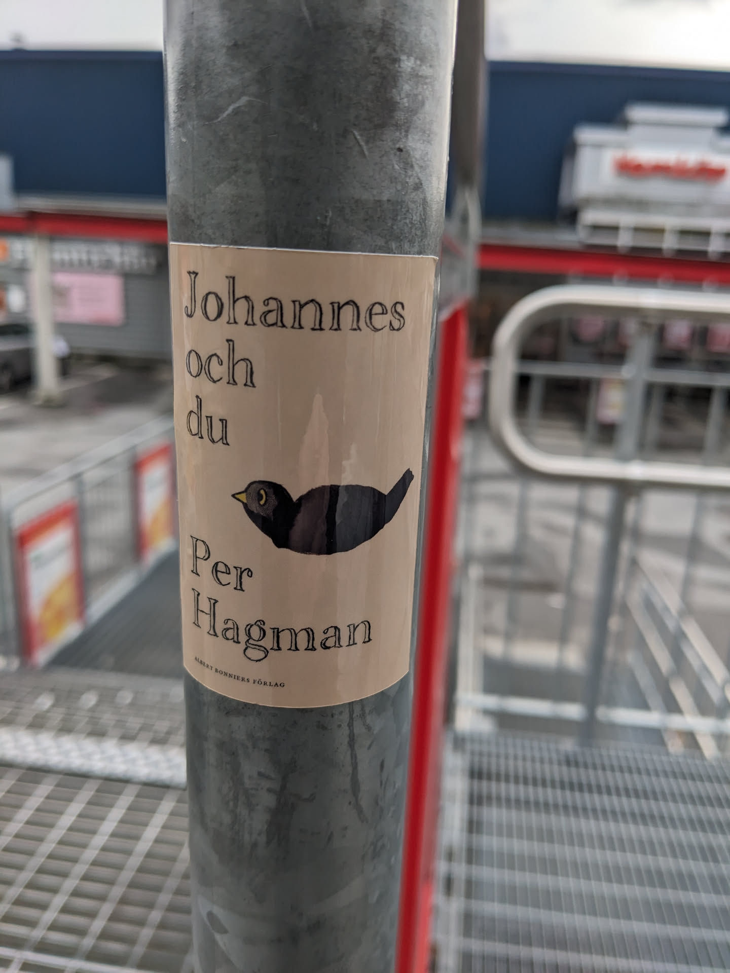 A beige sticker with a black bird illustration and text that says "Johannes och du Per Hagman".
