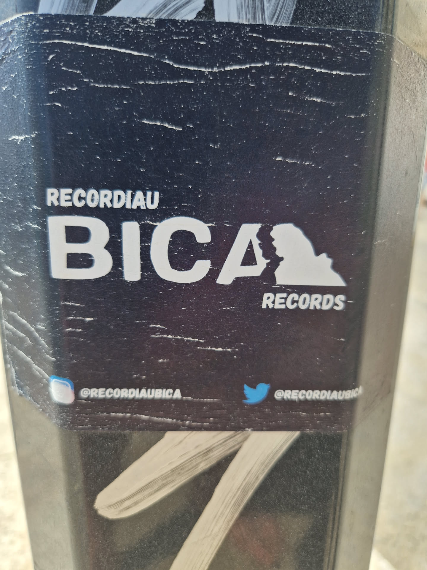 Black and white sticker with the text "RECORDIAU BICA RECORDS" and a graphic element resembling a stylized map.  Social media handles are included for Instagram and Twitter.