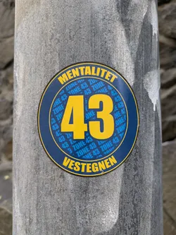 Round sticker with the number 43 in the center. The words 'MENTALITET' and 'VESTEGNEN' are written at the top and bottom respectively. The number 43 and the words 'ZONE 43' are repeated around the number 43 in smaller font. 