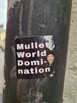 A sticker featuring a man with a mullet and the text "Mullet World Domination".