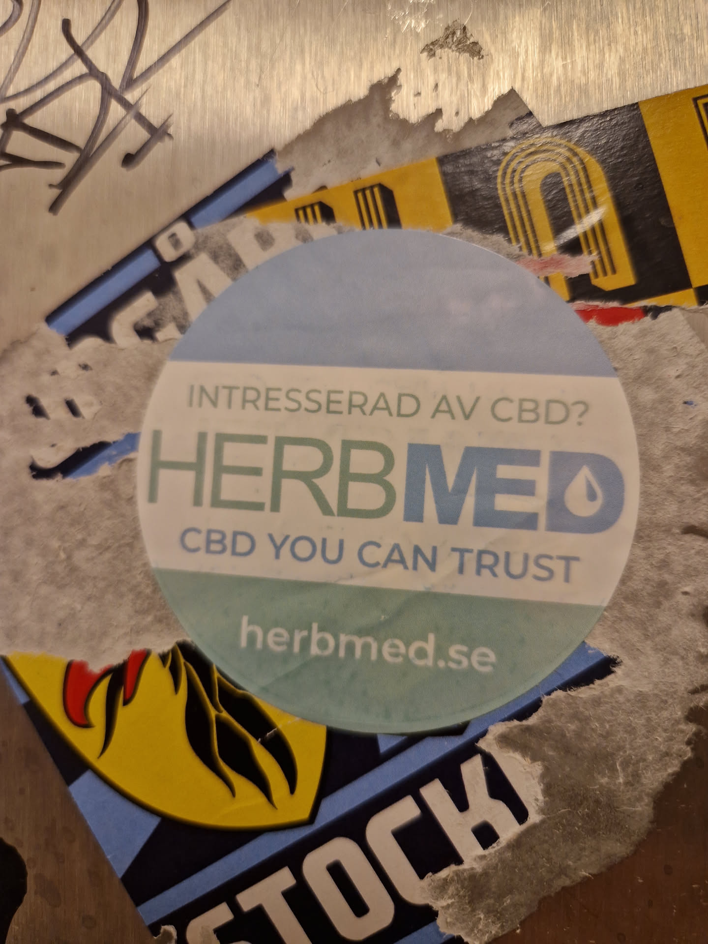 Round sticker with light blue background, promoting Herbmed and their CBD products.  The text includes 'Intresserad av CBD?' (Interested in CBD?) and their website address.