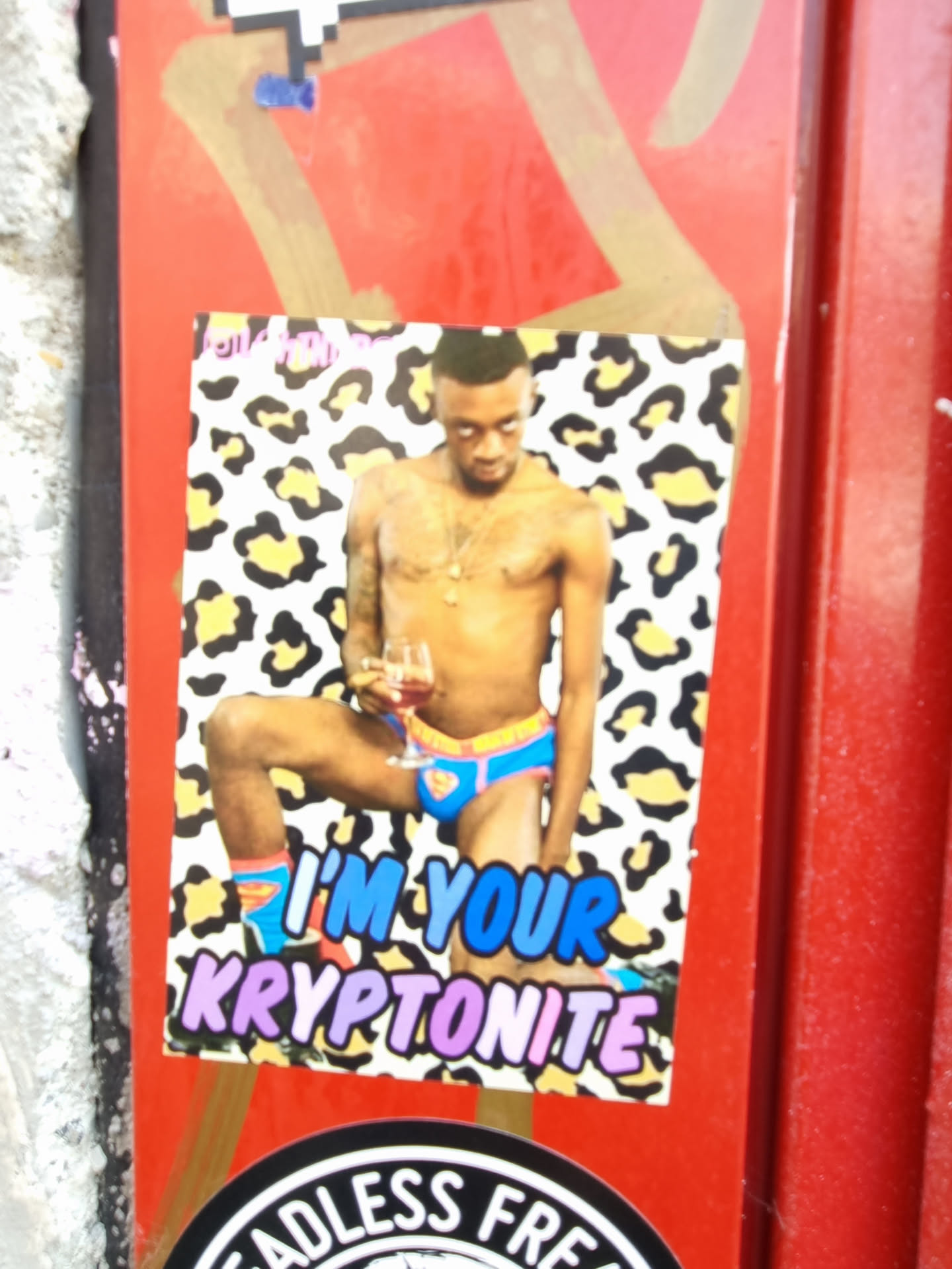 Sticker featuring a shirtless man with a glass of wine against a leopard print background. The text 'I'm your kryptonite' is written below the image.