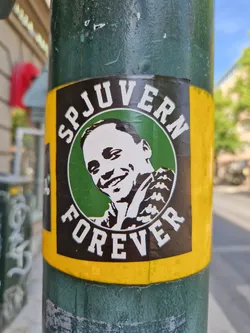 A sticker featuring a portrait of a man, with the text 'SPJUVERN' at the top and 'FOREVER' at the bottom, all within a circular design on a green background inside a yellow border.