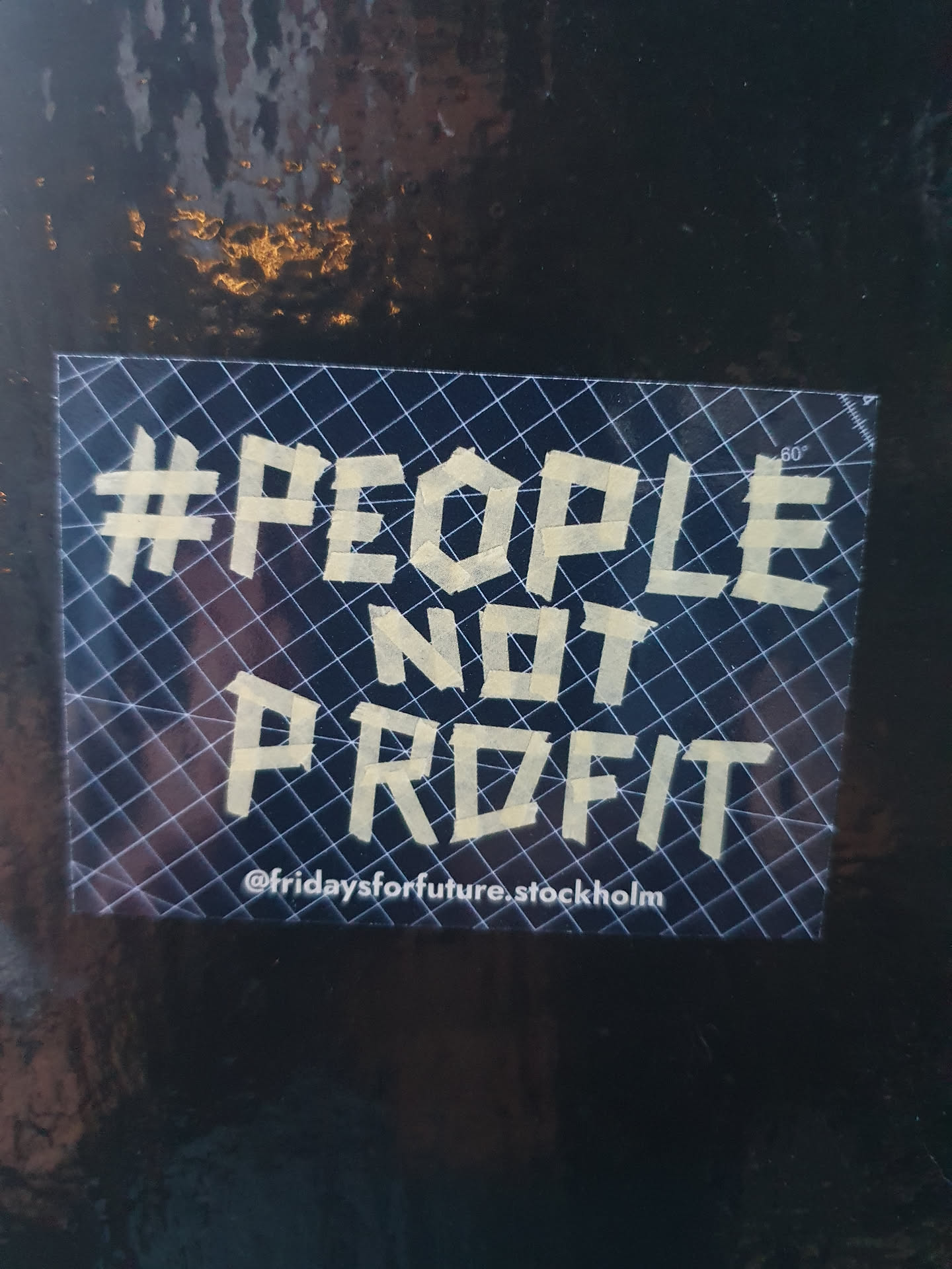 A sticker with the text '#PeopleNotProfit' and the social media handle @fridaysforfuture.stockholm. The text is written in a stylized font and appears to be made of tape.