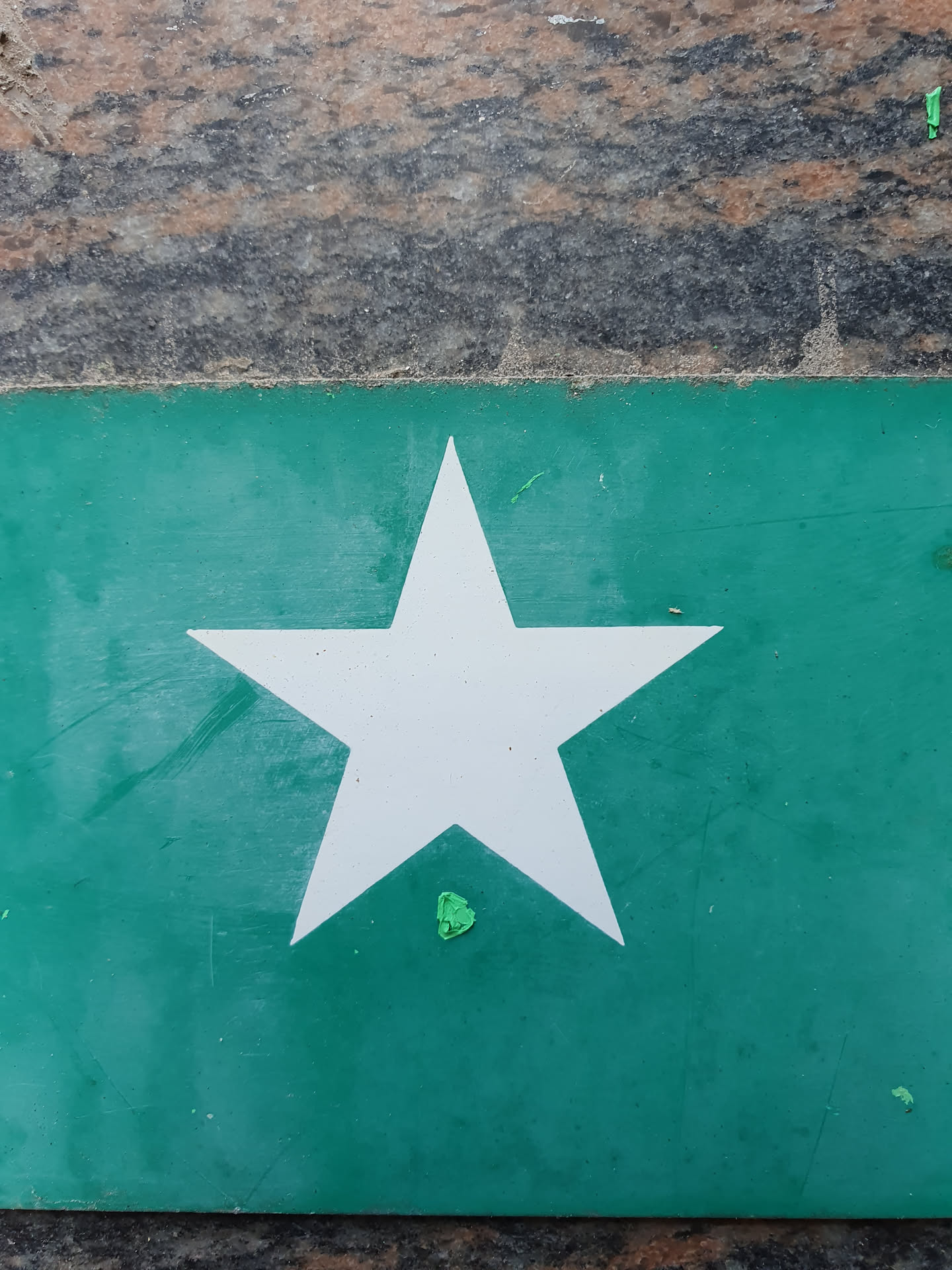 This sticker showcases a minimalist design with a white five-pointed star as the focal point against a teal green backdrop.  The color contrast is quite effective. The sticker itself appears to be made of a slightly textured material.
