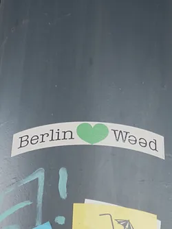 A sticker expressing love for weed in Berlin.  The sticker features the words 'Berlin' and 'Weed' with a green heart symbol in between.