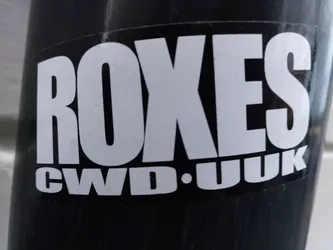 Close-up of a black and white Roxes CWD.UK sticker. The sticker has a bold, simple design with the brand name prominently displayed.