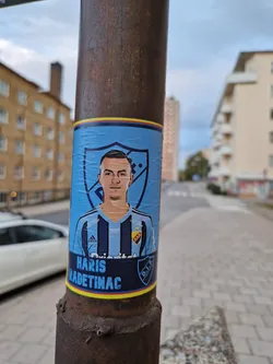 A sticker featuring Haris Radetinac, a football player from Dalkurd FF.  The sticker has a blue and yellow color scheme and shows a stylized portrait of the player in his team's kit.
