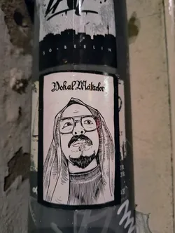 The sticker shows a black and white illustration of Vokal Matador, a person with glasses and a head covering, smoking a cigarette. The text 'Vokal Matador' is written in gothic font above the portrait.
