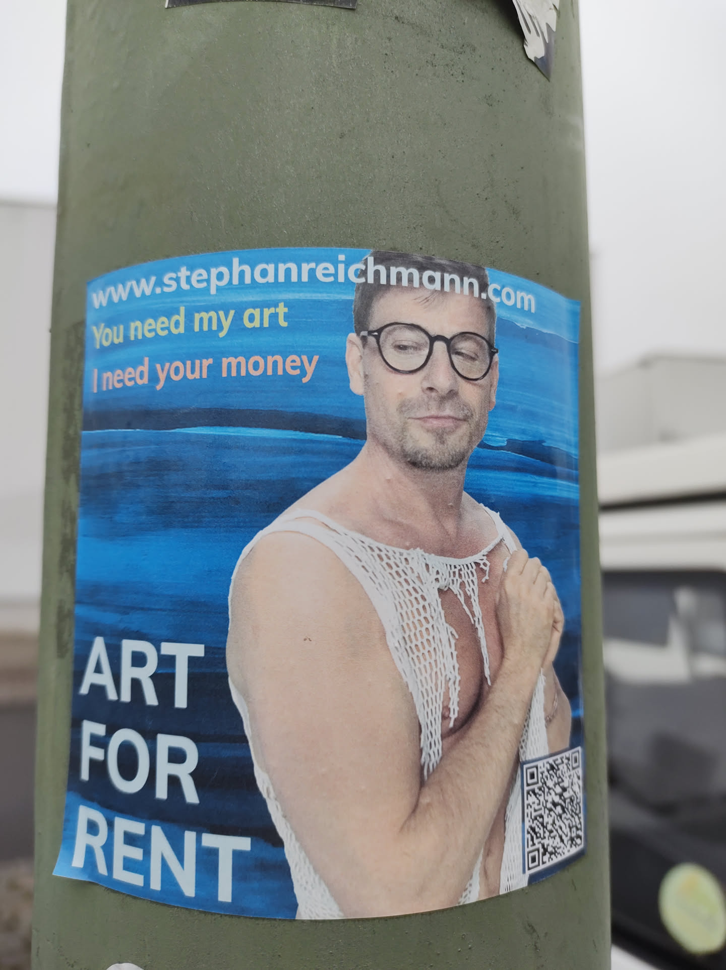 Sticker featuring a man in a crocheted top against a blue background.  The sticker includes a website address and a QR code.