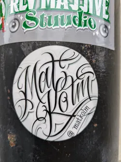 Round sticker with black lettering on a white background. The lettering says "Matt Kolm" in a stylized script font.  There's a small @matkolm signature at the bottom.
