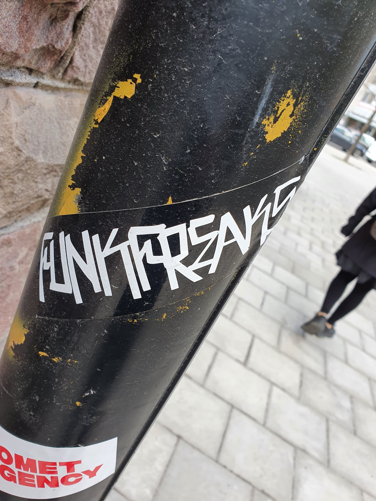 A white sticker with the text "Funkforskare" in a stylized, graffiti-like font on a dark surface. The sticker shows some signs of wear.