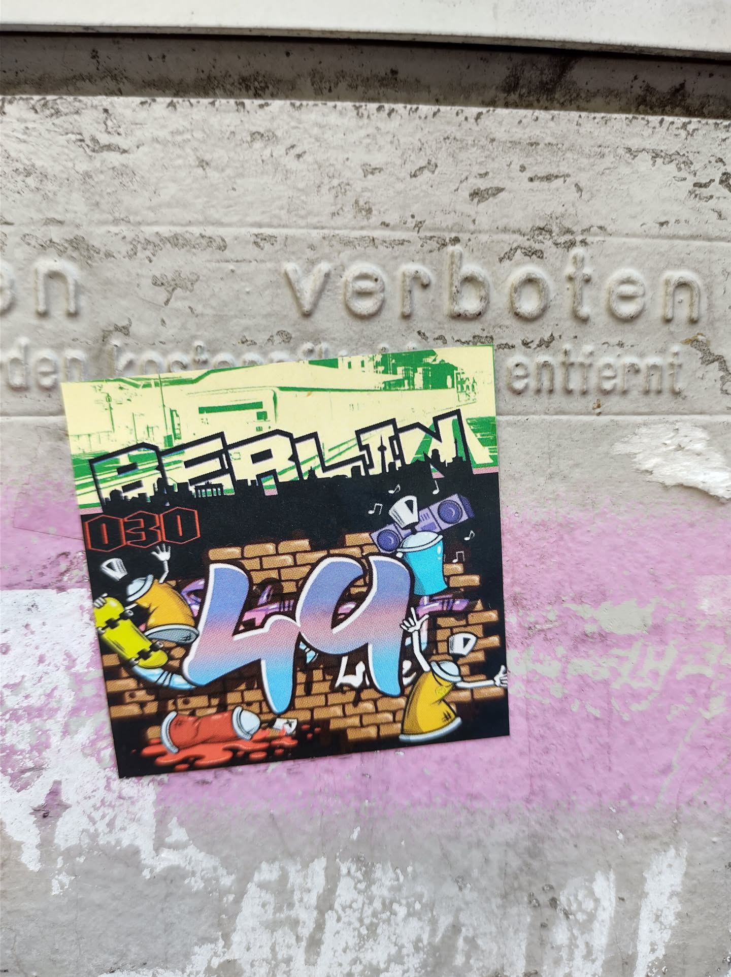 A sticker featuring graffiti art with the number 44 prominently displayed. The style is reminiscent of street art, with cartoonish characters and spray paint cans included in the design. The sticker also features the word 'BERLIN' at the top, suggesting a connection to the city. There's a small '030' near the top left, which might be an area code.