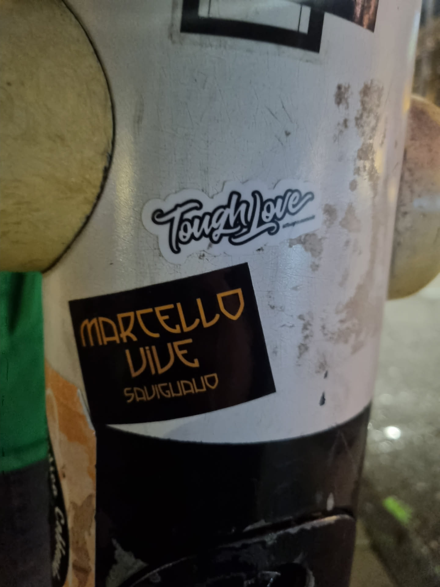 A black and gold sticker with the text "MARCELLO VIVE" stacked over "SAUGUADLO" on a black background.  Above it is a white sticker with the text "Tough Love" written in a stylized script font.