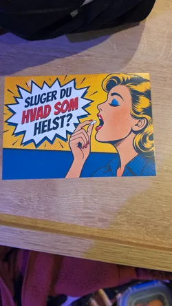 Street sticker A rectangular sticker designed in a classic vintage comic pop-art style with Ben-Day dot shading. On the right side, a blonde woman in profile with bright blue eye shadow and red lipstick raises a white pill to her open mouth. To the left, a jagged white speech bubble framed in dark blue pops out against a yellow background, containing the bold text 'SLUGER DU HVAD SOM HELST?' with the top and bottom words in dark blue and the middle words in red.