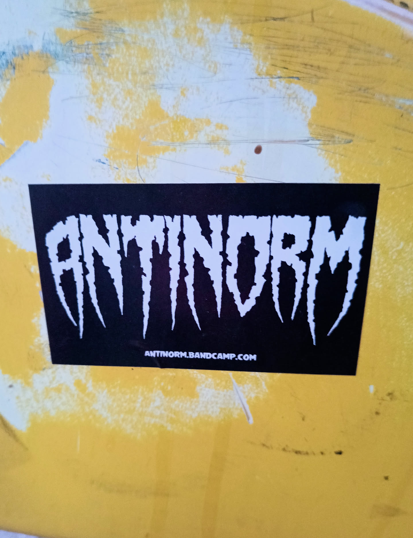 Black and white sticker with the band name ANTINORM in a stylized font.  The band's Bandcamp URL is printed at the bottom.
