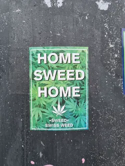 A sticker with a cannabis leaf design and the text "HOME SWEED HOME" and "SWISS WEED".