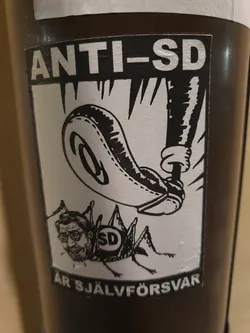 Black and white sticker with an illustration of a foot crushing a cricket with a man's face. The cricket has the letters "SD" on its back. The text on the sticker says "ANTI-SD ÄR SJÄLVFÖRSVAR".
