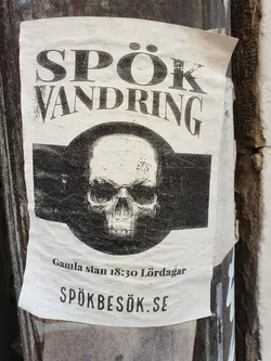 A sticker advertising a ghost walk in Gamla Stan, Stockholm. The sticker features a skull and the website spökbesök.se.
