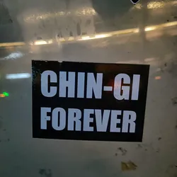 A black and white sticker with the text "CHIN-GI FOREVER" in bold, uppercase, white letters on a black background.