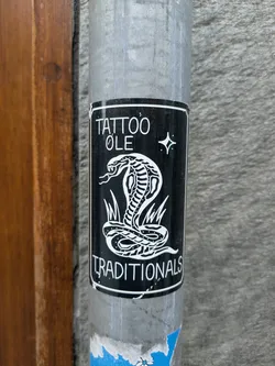 Black and white sticker with a traditional tattoo style cobra design.  The text 'Tattoo Ole' and 'Traditionals' is present, along with a small star graphic.