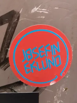 Round red sticker with a teal border. The name JOSEFIN EKLUND is written in a stylized teal font.