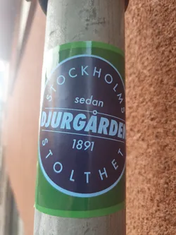 A round sticker with green and purple colors. It says 'Stockholms sedan Djurgården 1891 Stolthet' which translates to 'Stockholm since Djurgården 1891 Pride'