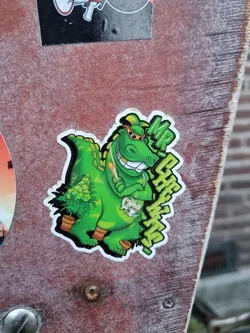 Sticker featuring a cartoon crocodile holding a cannabis plant. The crocodile is wearing sunglasses and has a joyful expression. The text 'MR CROC WEED' is visible on the sticker.