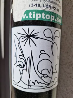 The sticker features a simple, elegant design. The main focus is a dandelion with its seeds dispersed, and next to it there is a smaller plant. The lines are clean and precise, creating a sense of simplicity and sophistication. The sticker is affixed to a dark surface and is slightly worn. 