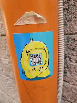 A yellow cartoon character in a zen pose is featured on this sticker.  The character has a simplistic design and is sitting peacefully. A QR code is prominently displayed on the character's stomach. The sticker has a bright blue background.