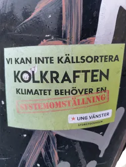 A green sticker with text in Swedish that translates to: We cannot recycle coal power. The climate needs a system change.  The sticker features the logo of Ung Vänster (Young Left) Storstockholm.