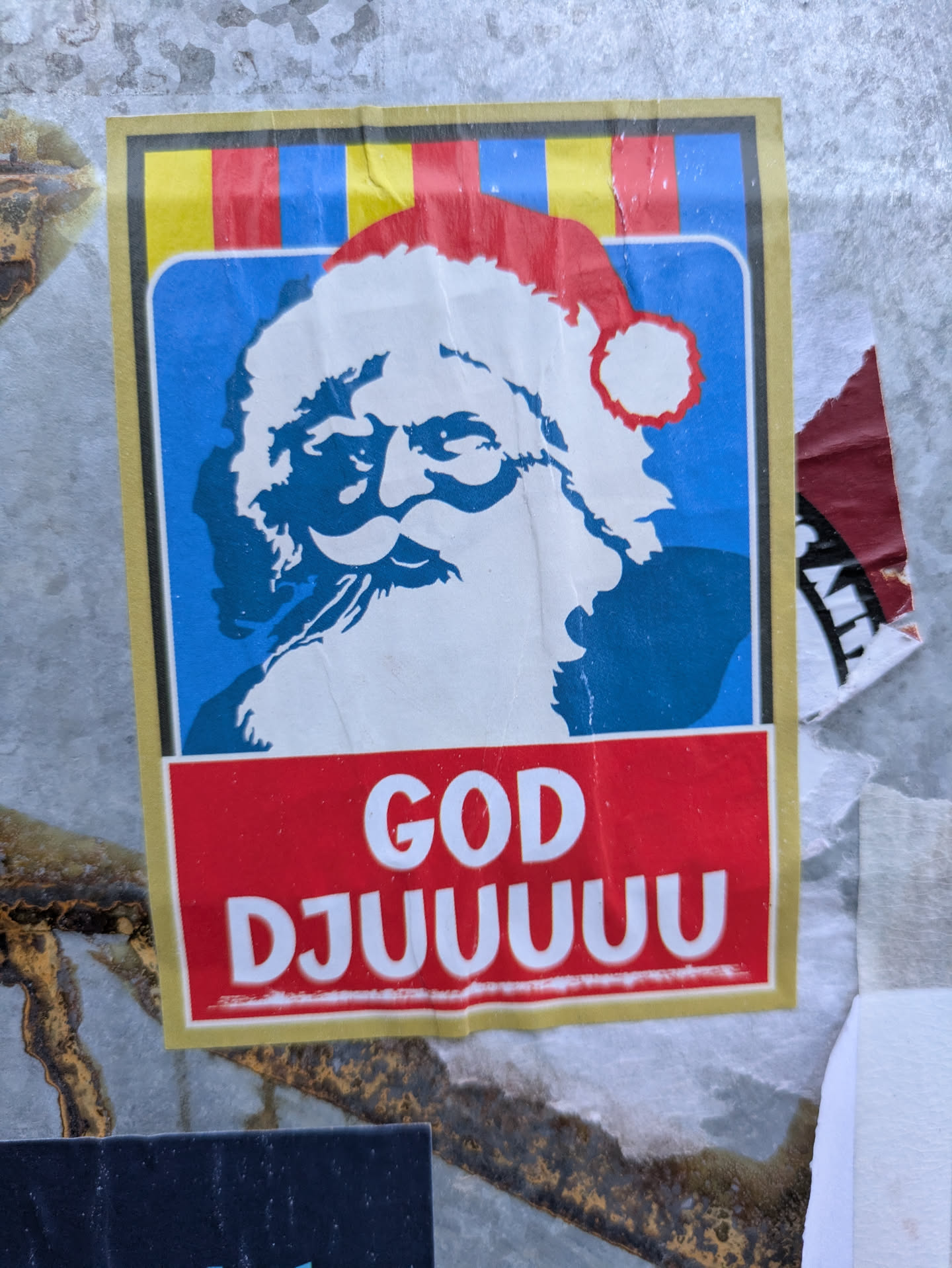 A vintage-style Christmas sticker featuring a stylized image of Santa Claus and the text "GOD DJUUUUUU", which is a playful and slightly exaggerated way of saying "God Jul" (Merry Christmas) in Swedish.