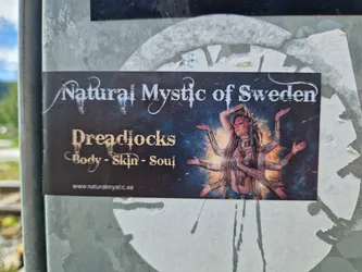 Sticker featuring a woman with dreadlocks and multiple arms, in a cosmic setting. The text on the sticker reads "Natural Mystic of Sweden" and "Dreadlocks Body - Skin - Soul".  A website address is also included.