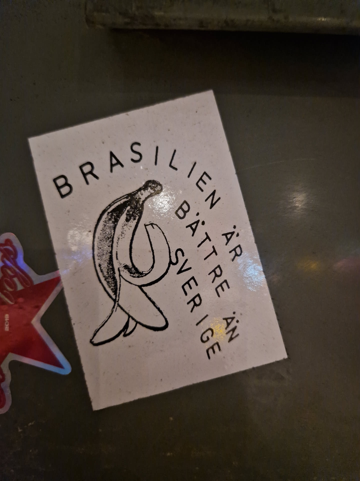 A sticker with a minimalist design featuring a banana and the text "BRASILIEN ÄR BÄTTRE ÄN SVERIGE", which translates to "Brazil is better than Sweden".
