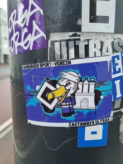 A sticker featuring a cartoon bird wearing a sailor hat and scarf, holding a HSV logo. In the background there is a drawing of the Volksparkstadion. The text "Castaways Ultras" is visible at the bottom of the sticker. The text "Hamburger Sport-Verein" is at the top of the sticker.
