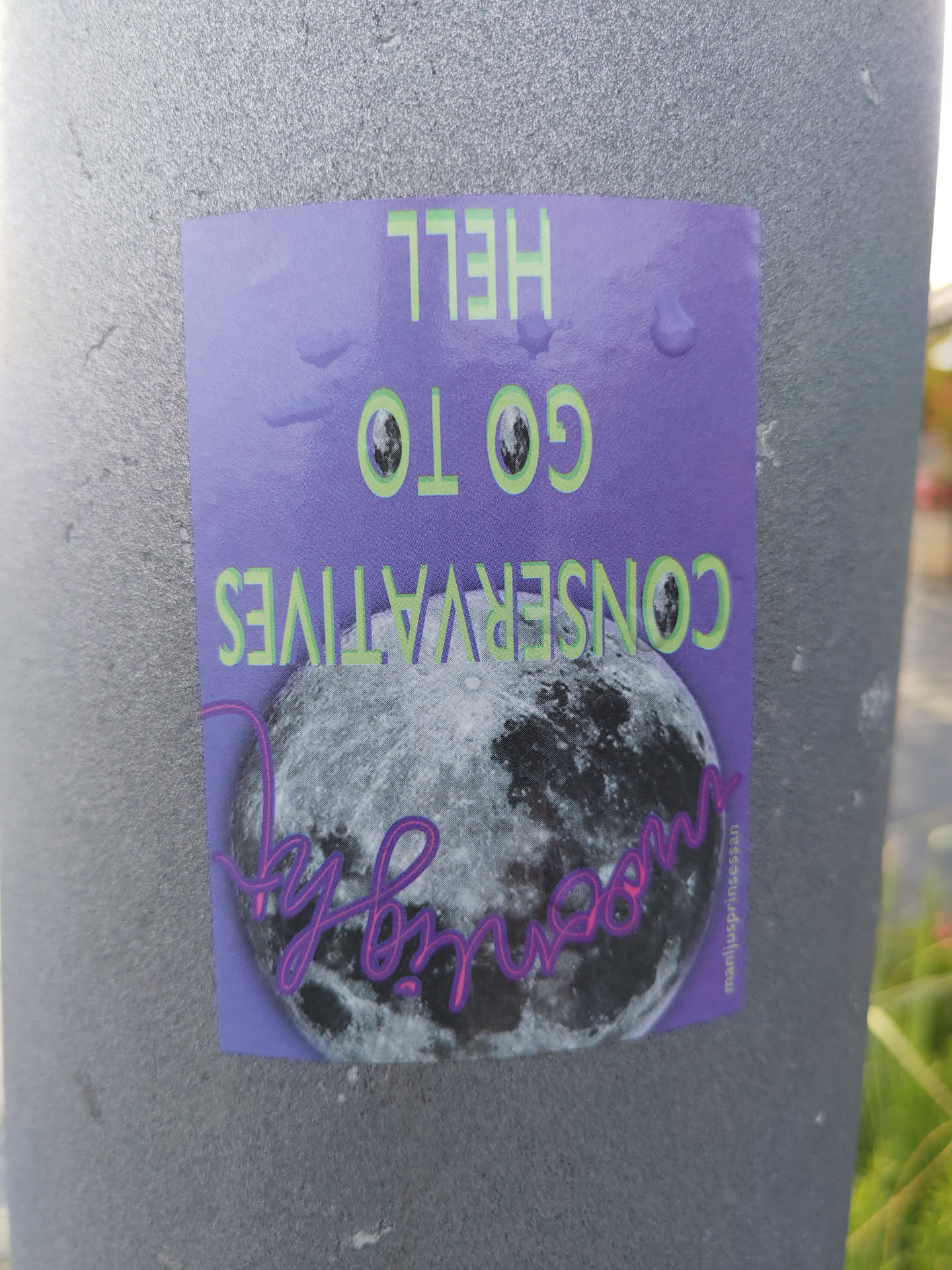 A sticker featuring a full moon and the text "Go to hell Conservatives". The sticker is predominantly purple with green text and has an artist signature on the bottom right corner.